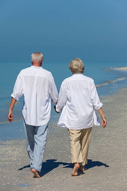 istock Happy Senior Couple Walking Holding Hands Tropical Beach 178115633