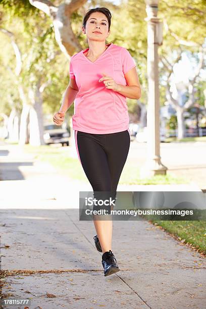 Female Runner Exercising On Suburban Street Stock Photo - Download Image Now - 30-39 Years, Active Lifestyle, Activity