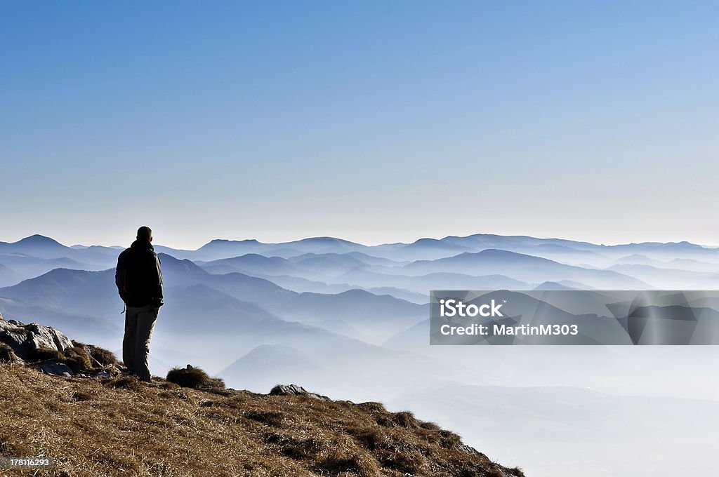 Misty mountain hills and silhouette of a man Misty mountain hills and silhouette of a man looking in the distance Adult Stock Photo