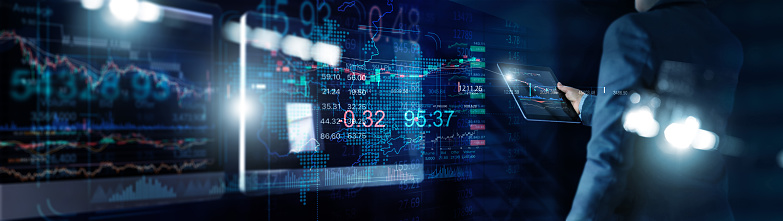 Businessman using tablet for analyzing data stock market in monitoring room with data in the chart on screen, Stock traders, Graph chart and trading, Investment of Financial and stock market.