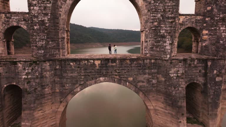 two tourists walking on the arch of the historic bridge