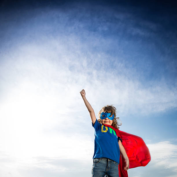 istock Small boy in superhero attire against blue sky 178118021