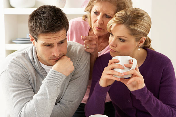 Senior mother talking with couple having an argument at home Senior Mother Interfering With Couple Having Argument At Home Pointing Looking Angry annoying mother in law stock pictures, royalty-free photos & images
