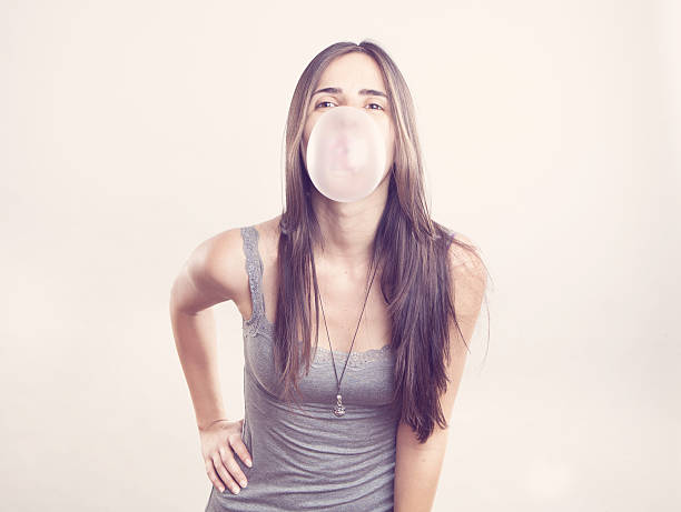 istock Young woman blowing a bubble gum 178120698