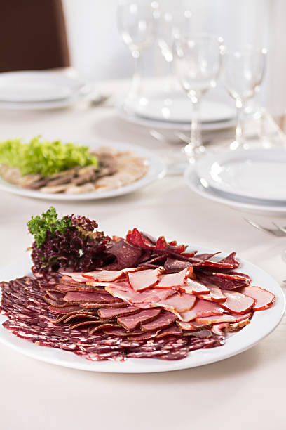 sliced sausages and ham on a plate stock photo