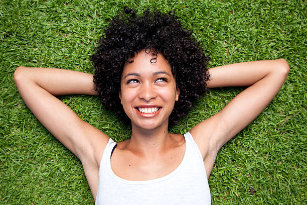 istock Curly haired woman smiling white laying in the grass 178121172