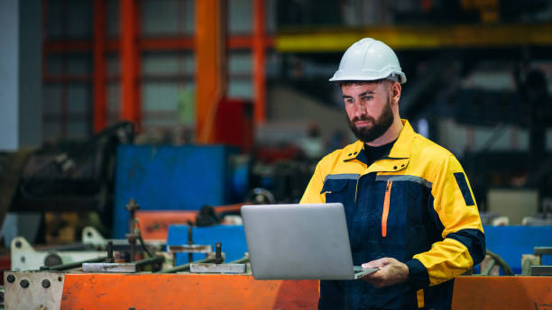 istock Industrial worker inspecting with laptop machine at factory machines. Technician working in the metal sheet company. 1781239792