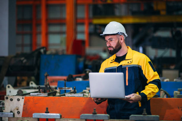istock Industrial worker inspecting with laptop machine at factory machines. Technician working in the metal sheet company. 1781241396