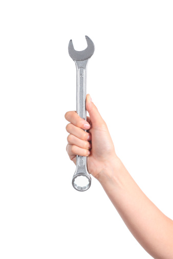 Woman hand holding a spanner isolated on a white background