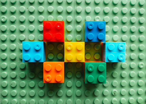 Colorful building blocks on green board. Toy blocks  background