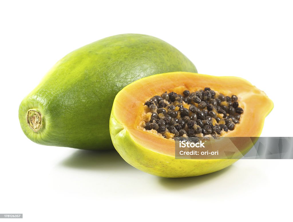 Half cut and whole papaya fruits Half cut and whole papaya fruits on white background Close-up Stock Photo