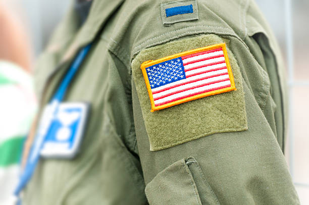 American flag on USAF uniform of person. Part of uniform of United States Air Force. Person wearing military clothes with pockets and national symbol. Focus on american flag in yellow frame attached to shoulder part of army clothing. officer military rank photos stock pictures, royalty-free photos & images