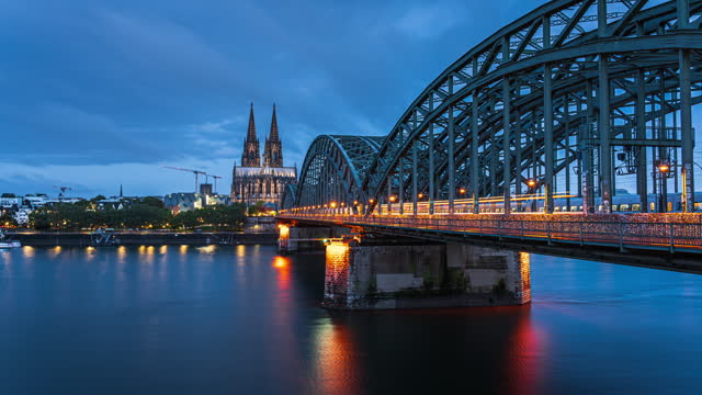 Day to night Time Lapse of Cologne Cathedral with Hohenzollern Bridge over the Rhine River in Cologne, Germany,
