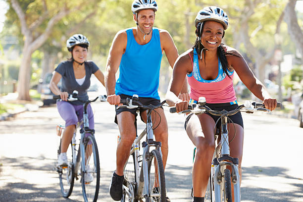 gruppo di ciclisti su strada suburbana - women muscular build action activity foto e immagini stock