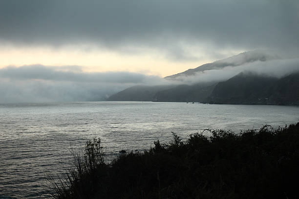 Nebbia sopra l'oceano al tramonto - foto stock