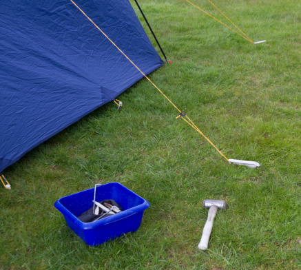 Variety of tent pegs being used to secure a tent on campsite