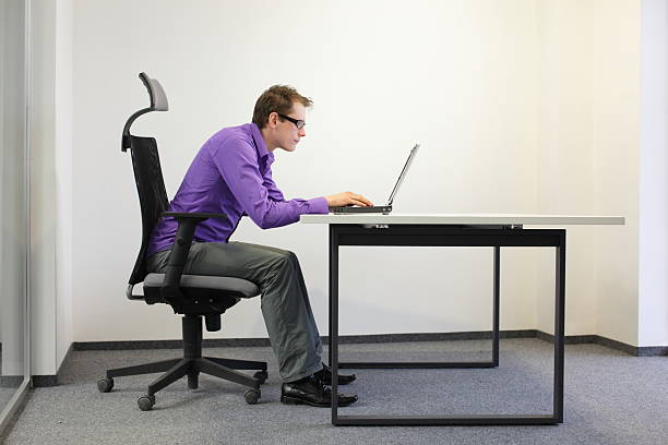 bad sitting posture at laptop bad sitting posture at laptop .short-sighted business man on chair in his office sitting position stock pictures, royalty-free photos & images