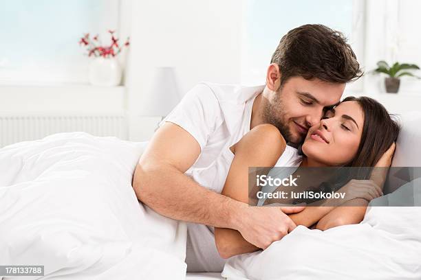 Young Adult Couple Cuddling In Their Bedroom Stock Photo - Download Image Now - Adult, Adults Only, Beautiful People