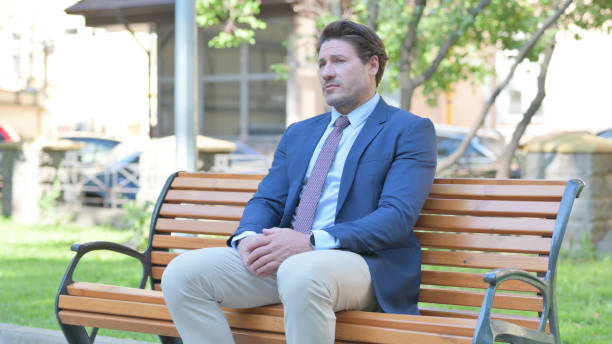 istock Serious Middle Aged Businessman Sitting Outdoor on Bench 1781353511