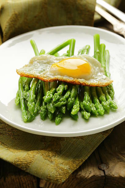 gourmet breakfast - asparagus with fried egg gourmet breakfast - asparagus with fried egg hollandaise sauce stock pictures, royalty-free photos & images