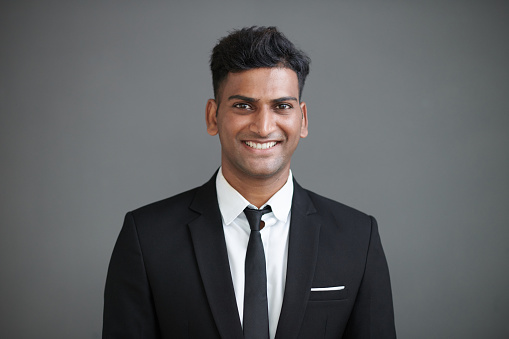 Studio portrait of smiling Indian entrepreneur in formal suit