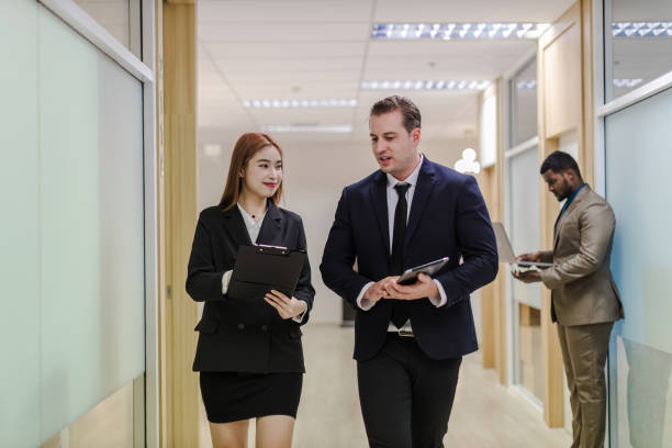 istock Diverse friend partners colleagues talking walking in modern office hallway. Confident business partners walking down in office building and talking. Professional business people walking and talking 1781360950