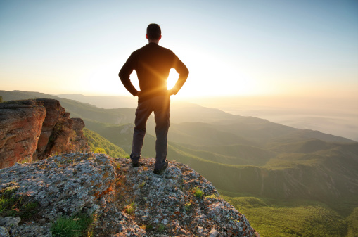 Silhouette of man on top of mountain. Conceptual scene.