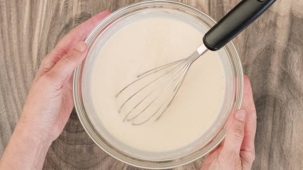 istock White chocolate vanilla bean pudding recipe. Mixing pudding mix and milk in a glass bowl, close-up view 1781373052