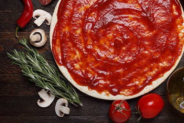 istock Fresh pizza dough with tomato sauce 178137370