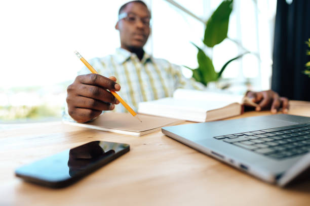 istock Serious concentrated african man studying or working with laptop indoors 1781379931