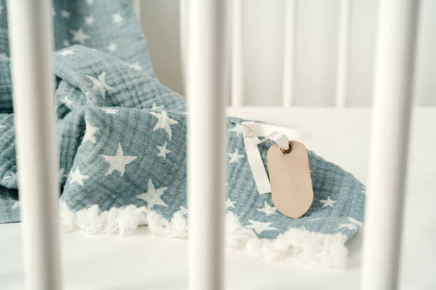 istock Soft blue muslin blanket hanging on a baby's bed 1781386565