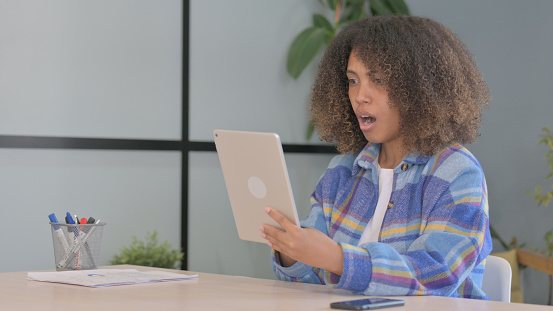 African American Woman Upset by Loss on Tablet