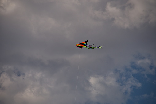 Colorful kite against cloudy sky