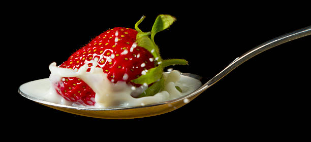 istock red, ripe strawberry falling in spoon with milk 178141886
