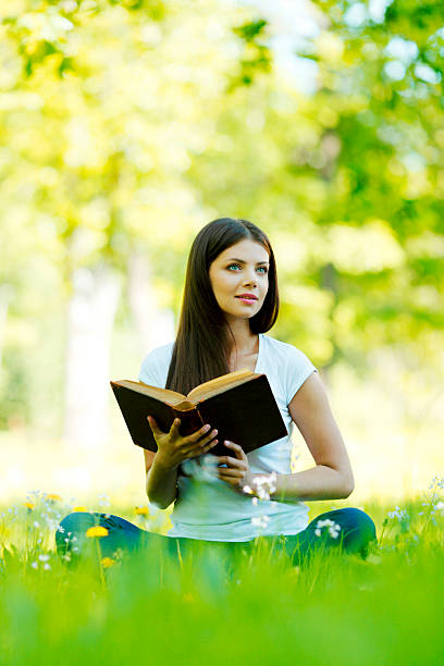istock Woman reading book outdoors 178142375
