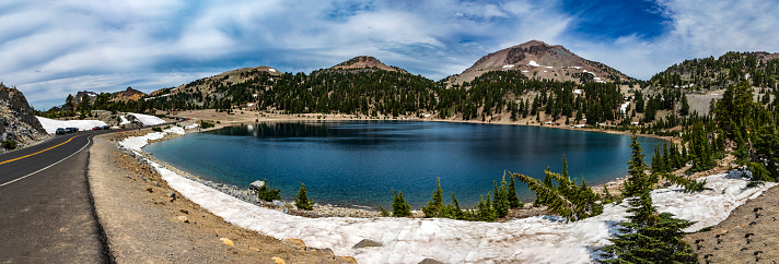 panoramic shot of turquiose blue Lake Helen in Lassen Volcano National Park in Northern California on a clear blue summer sky