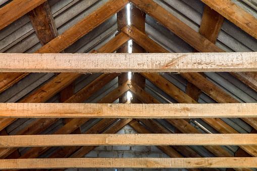 Wooden roof structure of a country house. Roof floor beams from the inside.