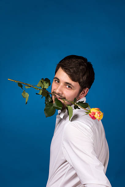 istock Young man holding a red rose in his mouth 178143490