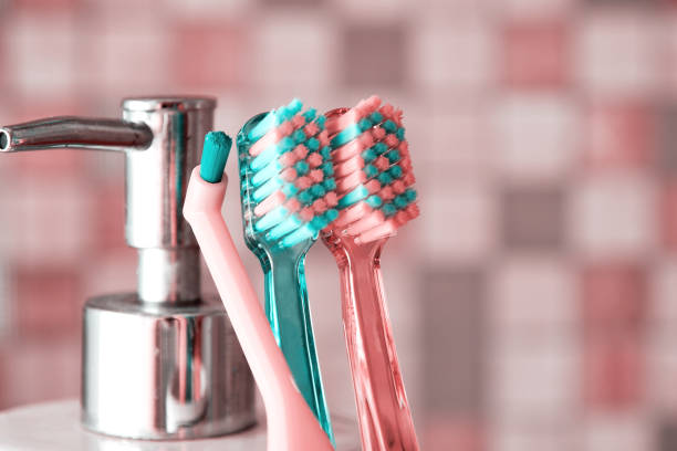 escovas de dentes rosa e turquesa no banheiro perto do frasco de sabão - toothbrush pink turquoise blue - fotografias e filmes do acervo