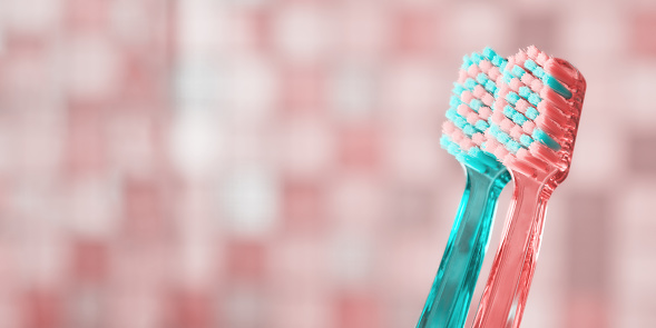 Banner with close up toothbrushes view and blurred tiles on the back. Healthcare and hygiene backgrounds. Copy space for text