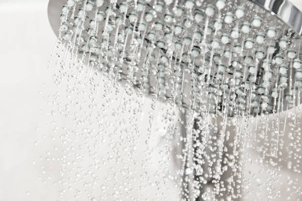istock Clean water drops pours from the shower head in the light bathroom 1781453867
