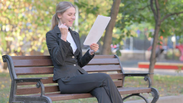 istock Businesswoman Celebrating and Reading Documents Outdoor 1781458669