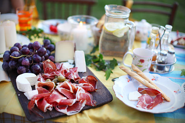 Prosciutto with cheese and grapes on a picnic table stock photo