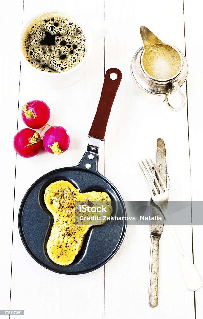Breakfast with fried eggs in fun form of penis Breakfast with fried eggs in fun form of penis in a frying pan with coffee and milk over white wooden background, top view Adult Stock Photo