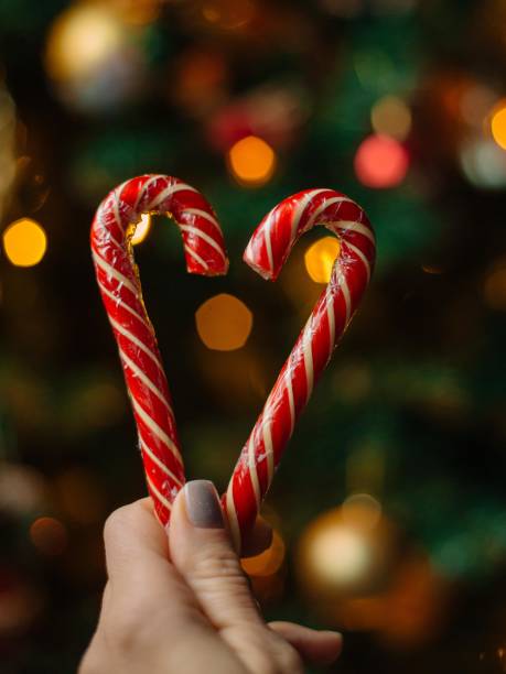 istock New Year's candy canes on a cozy blurred Christmas tree background with lights. candies and gifts for Christmas. New Year's Eve 1781481548