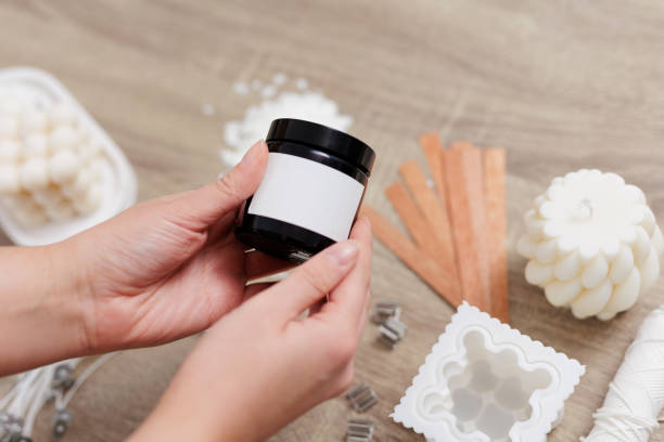 istock Woman hand holding handmade soy candle jar with white label with space for text 1781482311