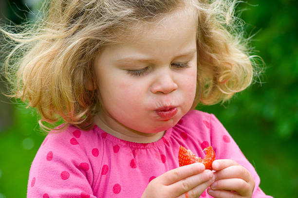 istock child is eating strawberry 178148597