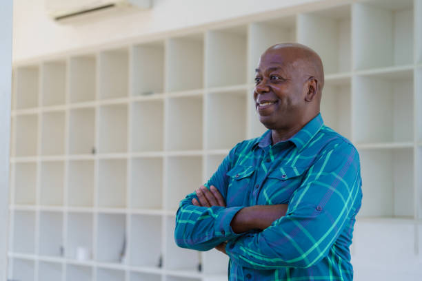 istock Enjoying retirement, smiling and happy senior man thinking, looking away, or standing alone with arms crossed. Elder and retired pensioner in an old age home, apartment, or house with arms folded. 1781488910