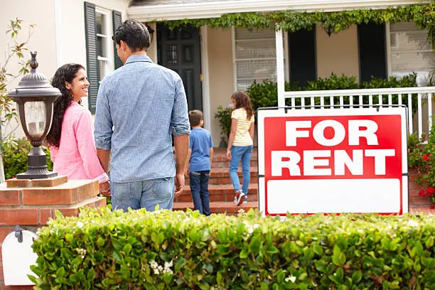 Photo of Smiling Hispanic family outside rental home