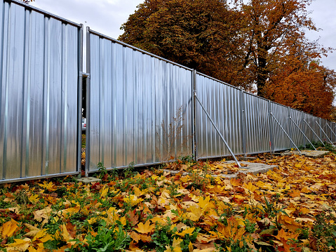 metal fence can be quickly erected and fenced off a construction site or concert venue with a temporary barrier made of sheet metal elements equipped with loads and struts against wind. safe, certified, developers, prevent, workspace